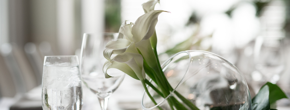 Floral arrangement on a table beside two glasses