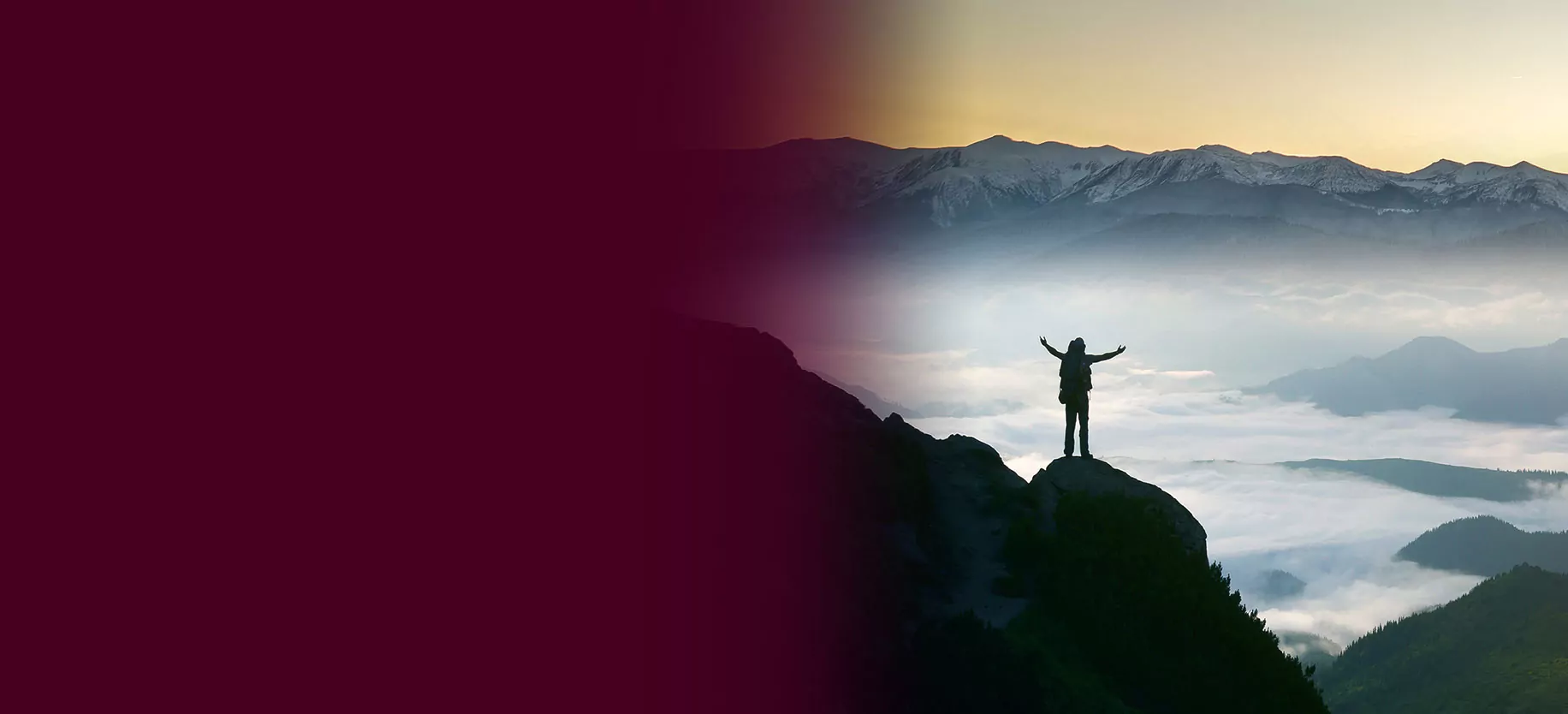 Silhouette of backpacker on rocky mountain slope with raised hands over valley