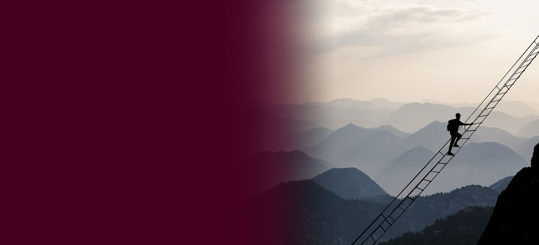 A person climbing a mountain on a rope ladder