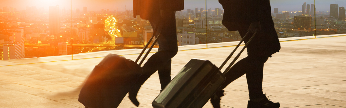 Two people pulling suitcases at an airport