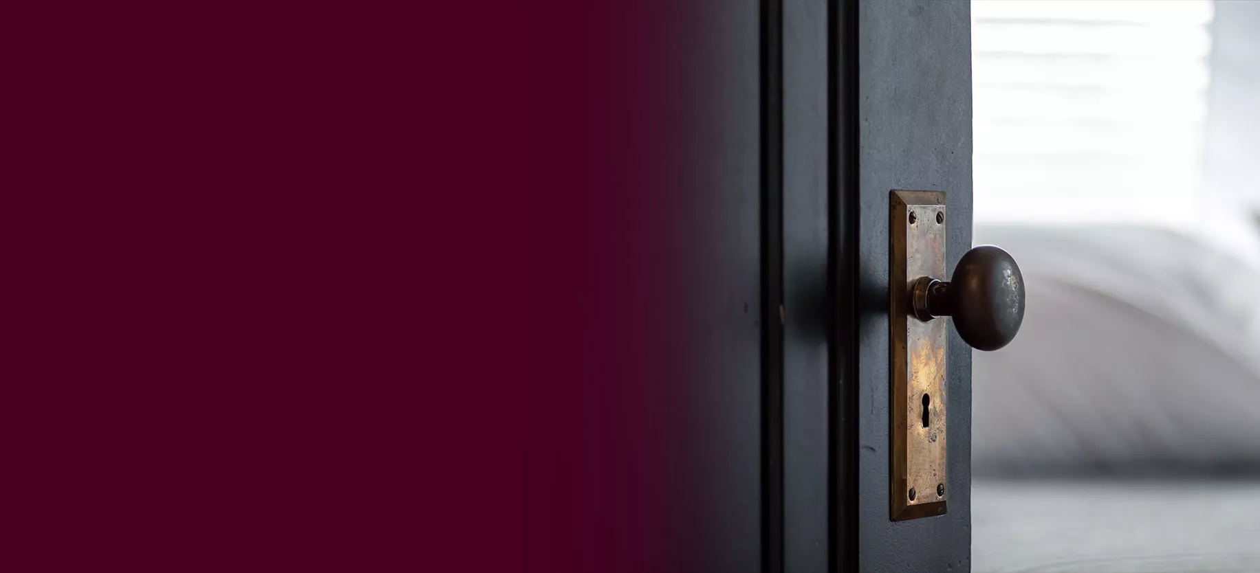 Close-up of a doorknob and open door