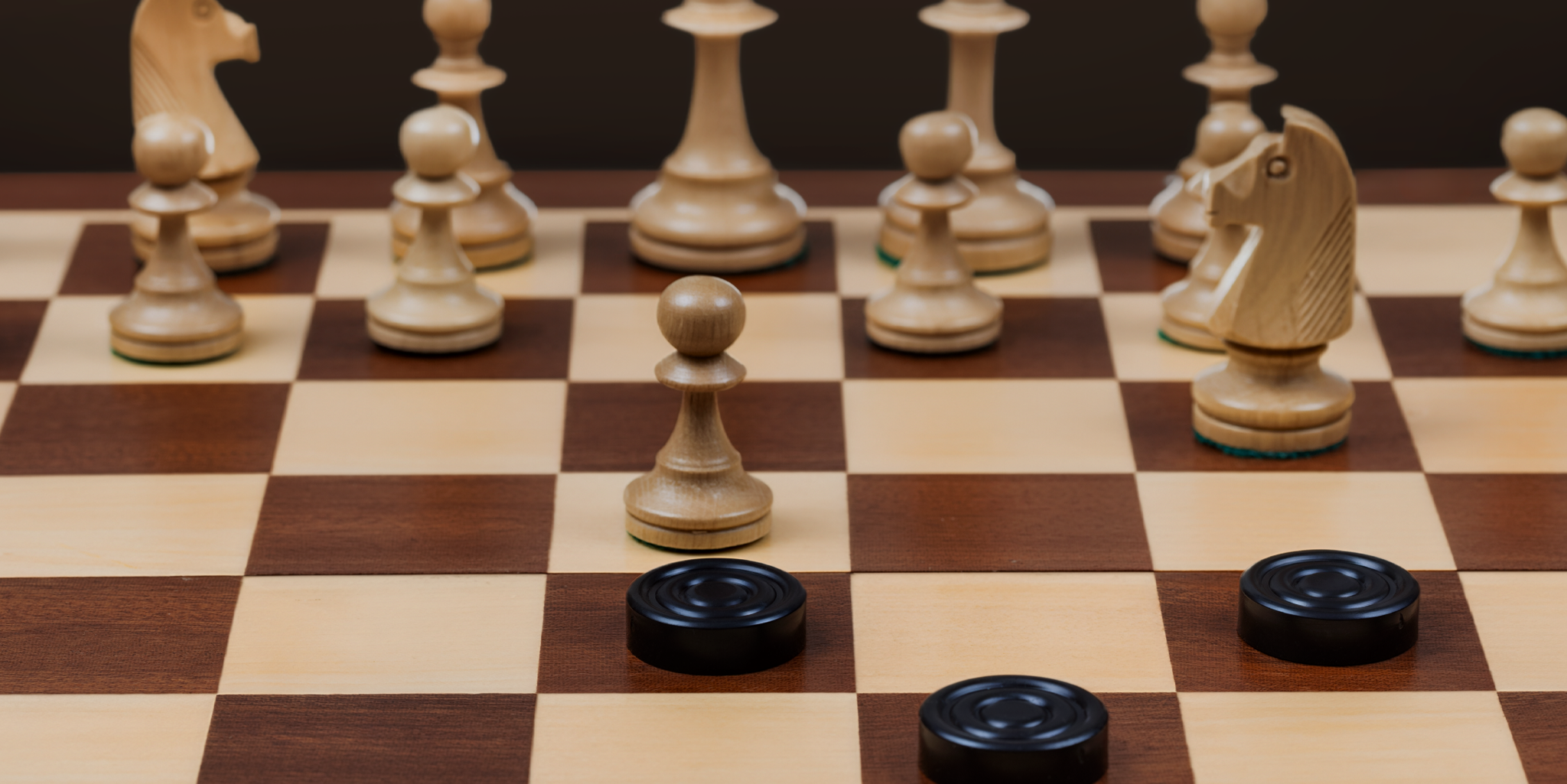 Close up image of a chess board with chess and checkers game pieces