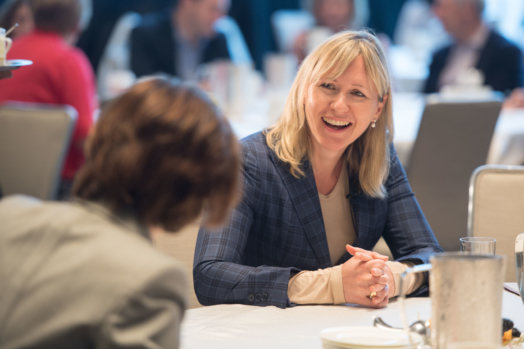 Anne Maggisano speaks with a client at a Women of Burgundy event