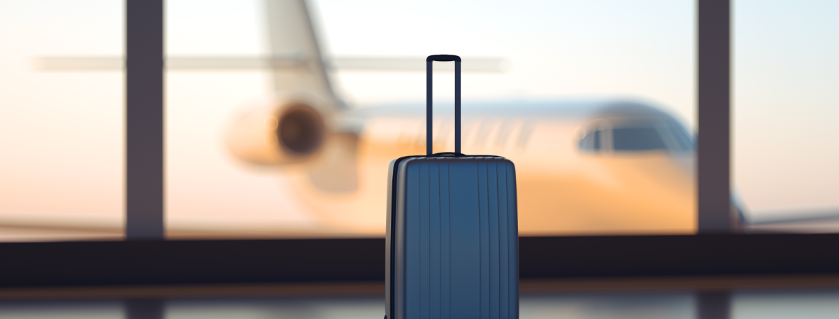 A suitcase in an airport with a plane visible through the window in the background