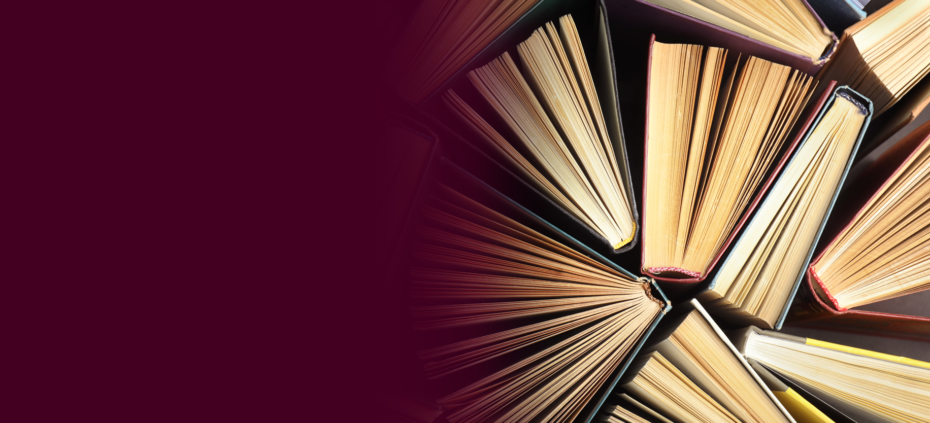 Many different hardcover books on dark background, top view