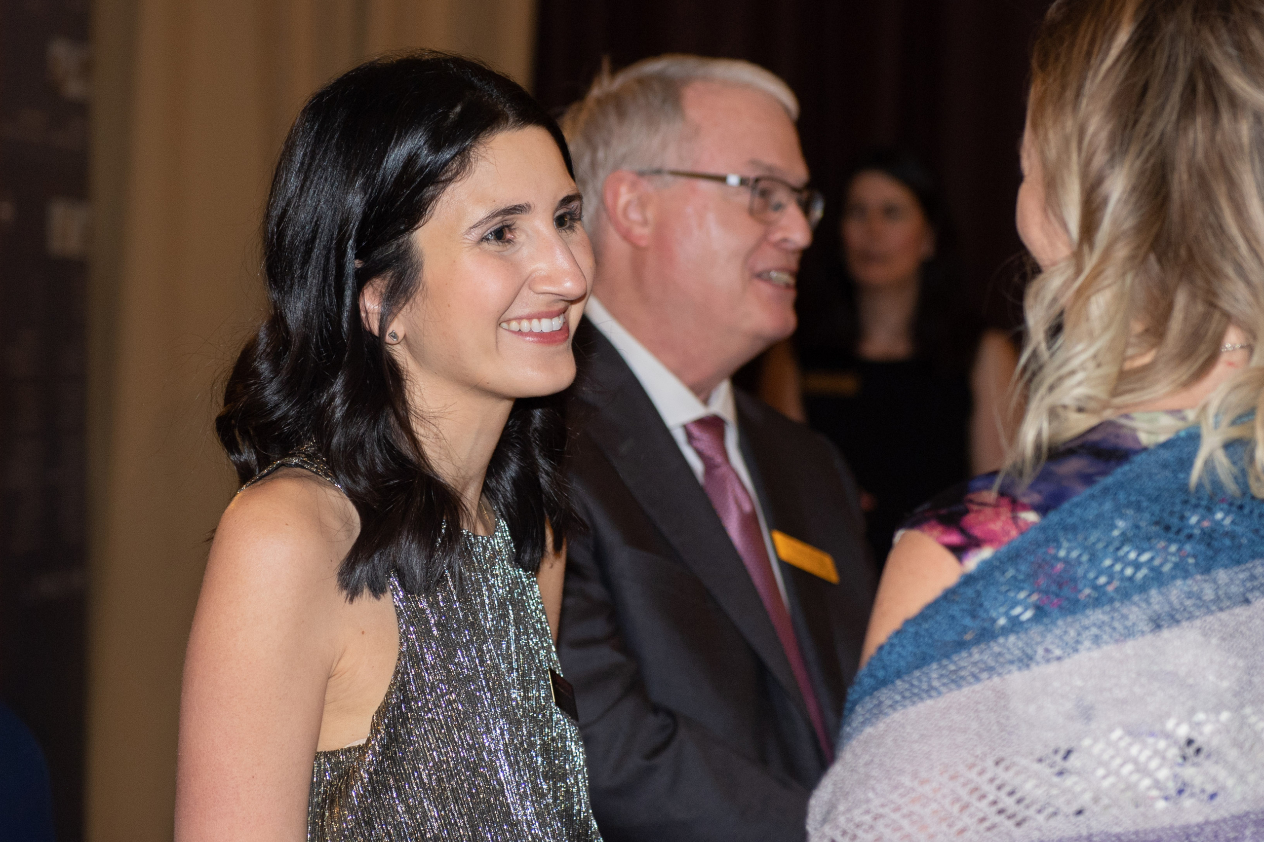 Lauren Landau speaks with a guest at the Burgundy Ball, with Richard Rooney beside her