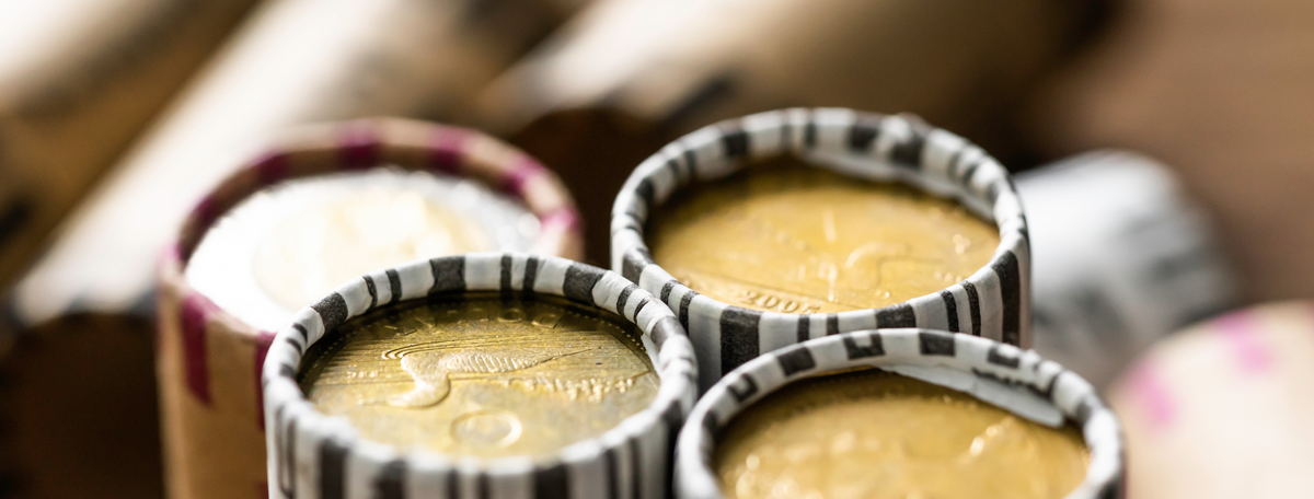 Canadian loonies (dollars) stacked in coin rollers