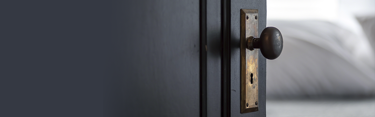 Close-up of a doorknob and open door