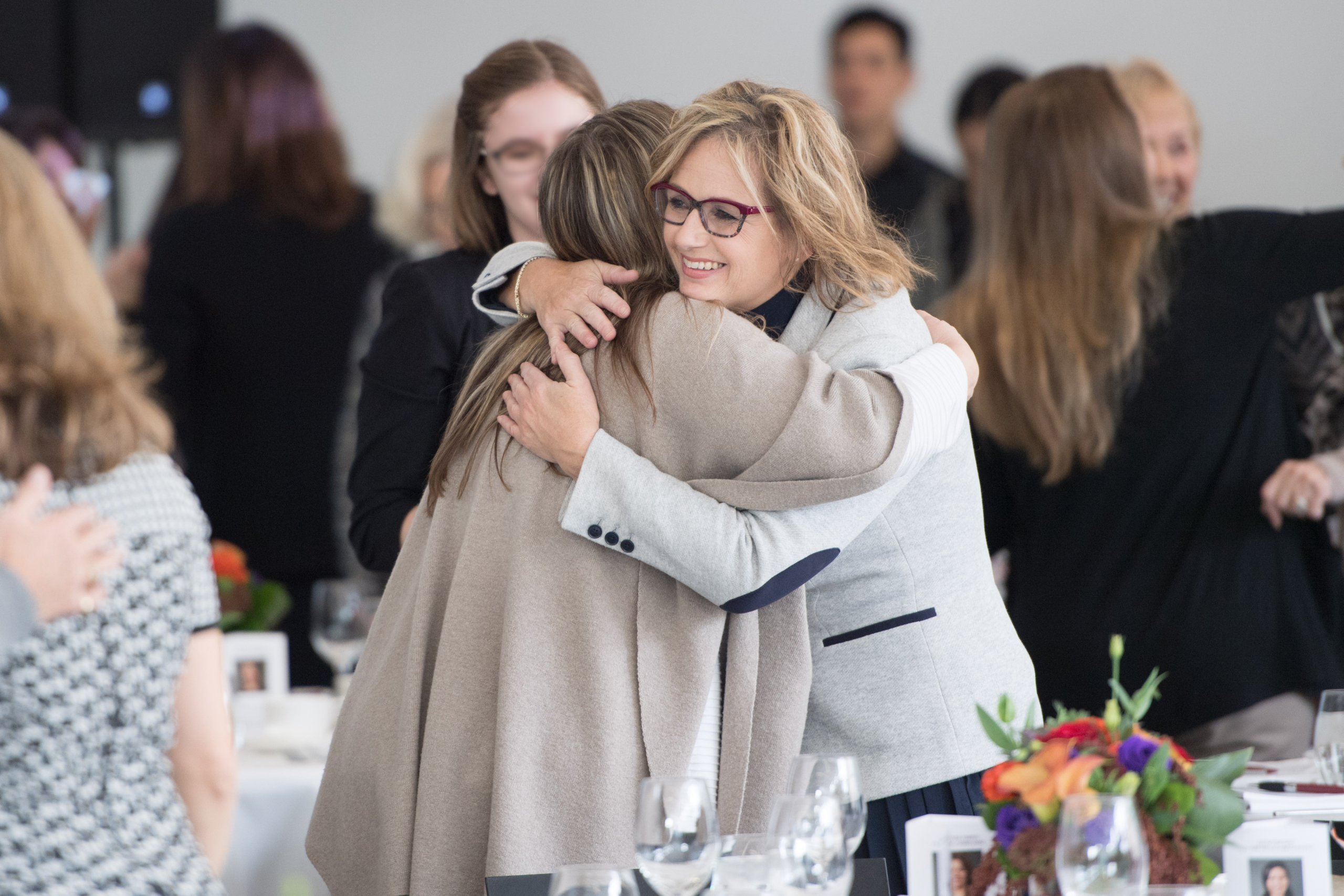 Della Langley hugging a client at a Women of Burgundy event